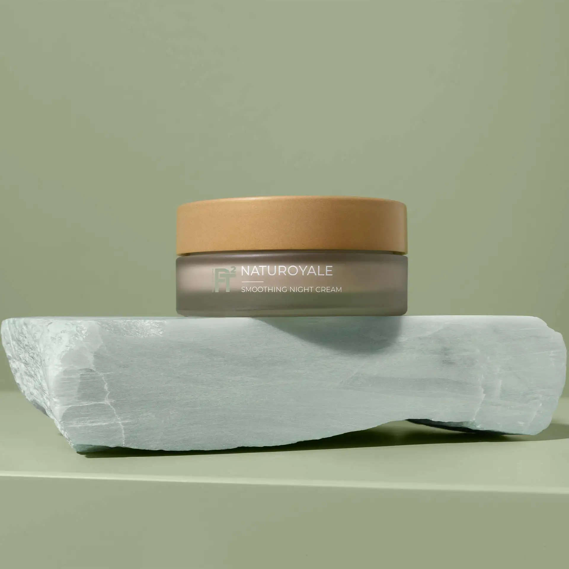 NATUROYALE Smoothing Night Cream im braunen Tiegel auf grauem Stein vor grünem Hintergrund