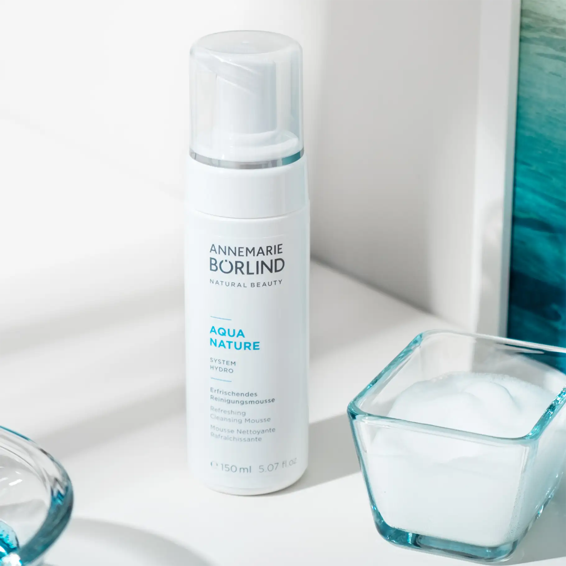 ANNEMARIE BÖRLIND AQUA NATURE erfrischendes Reinigungsschaum-Mousse in 150 ml Flasche neben Glas mit Schaum