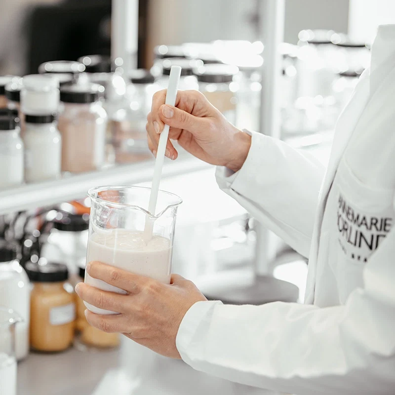 Mitarbeitende im Labor von ANNEMARIE BÖRLIND rührt eine cremige Formulierung in einem Becherglas