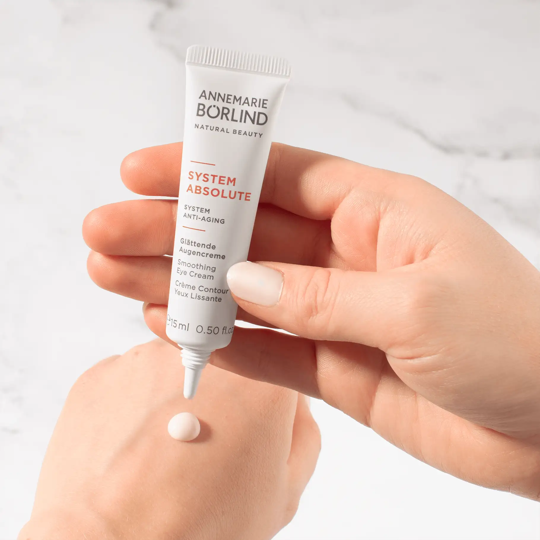 ANNEMARIE BÖRLIND SYSTEM ABSOLUTE glättende Augencreme in Hand mit Cremepunkt auf Handrücken