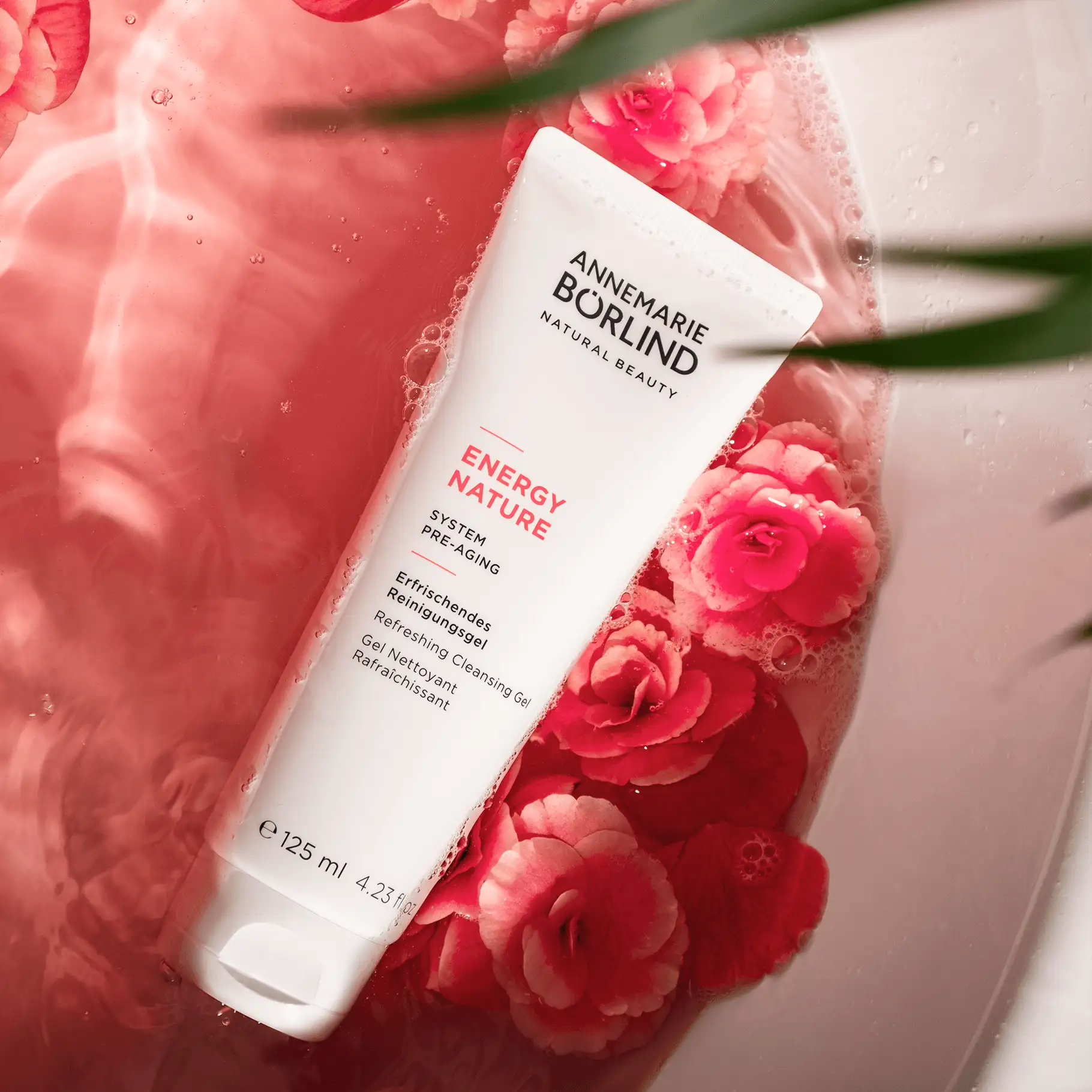 ANNEMARIE BÖRLIND ENERGY NATURE erfrischendes Reinigungsgel in weißer Tube mit rosa Blüten im Wasser