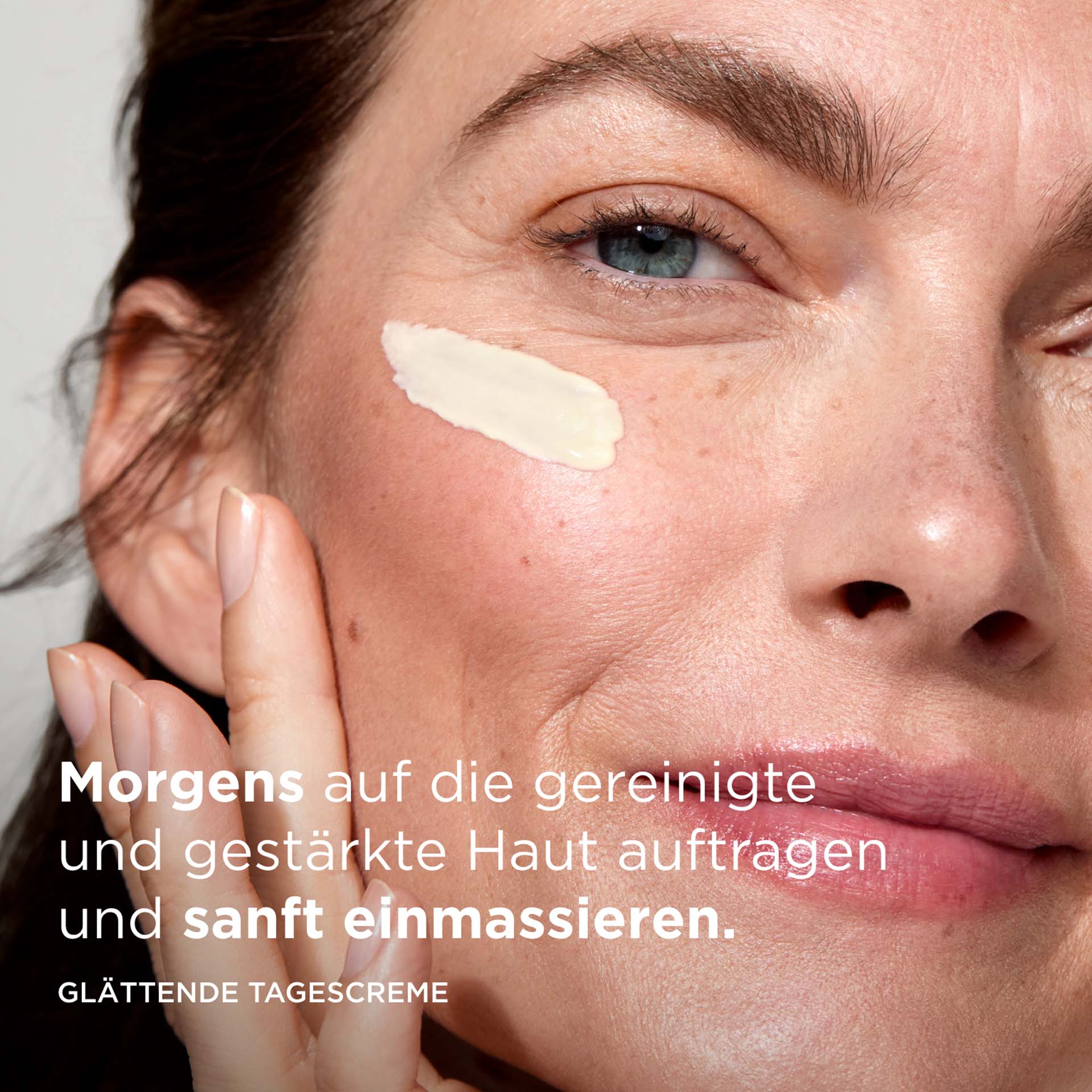 Model trägt SYSTEM ABSOLUTE Tagescreme im Gesicht auf, mit Anwendungstext