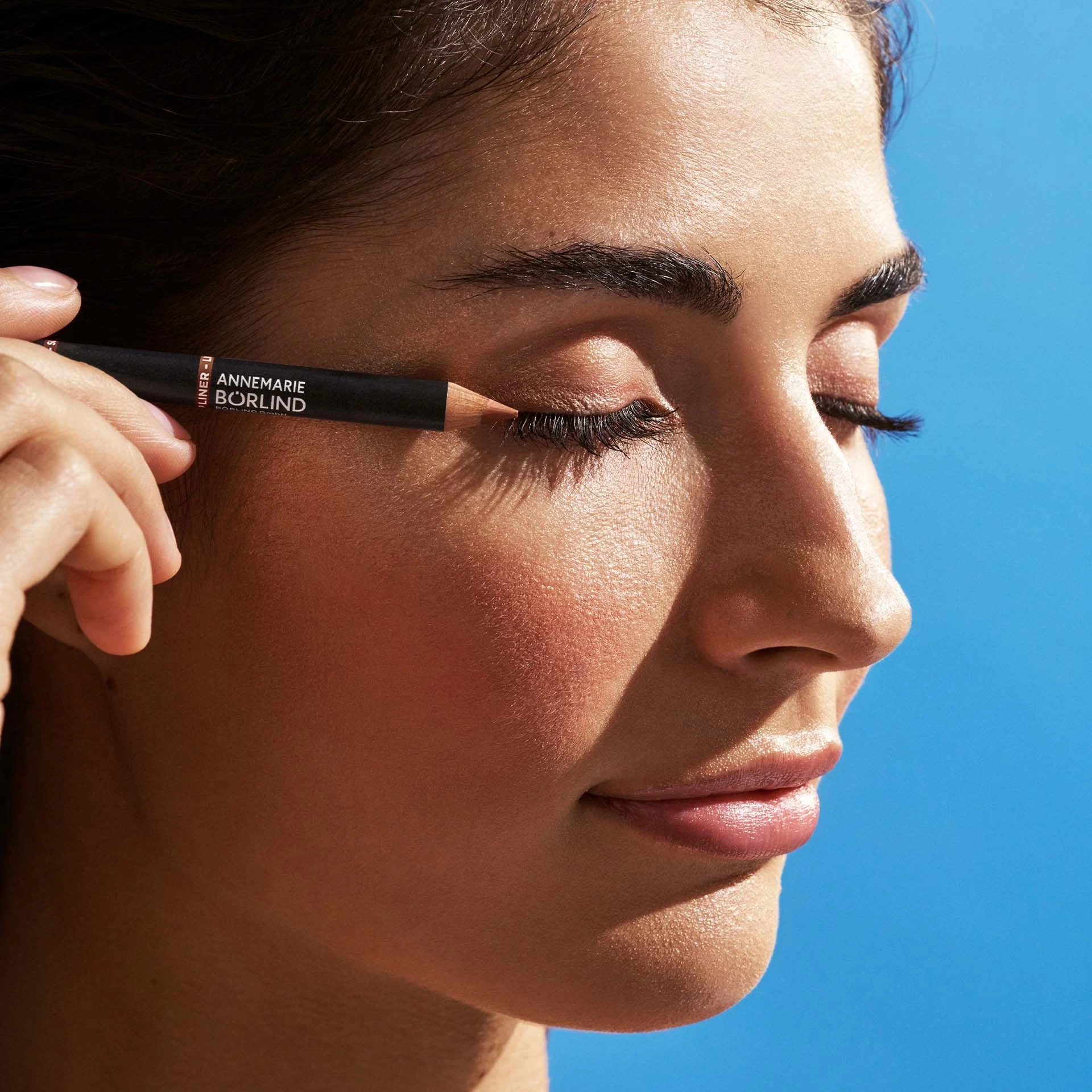 Frau trägt ANNEMARIE BÖRLIND Eye Liner Pencil auf dem oberen Augenlid bei geschlossenen Augen auf