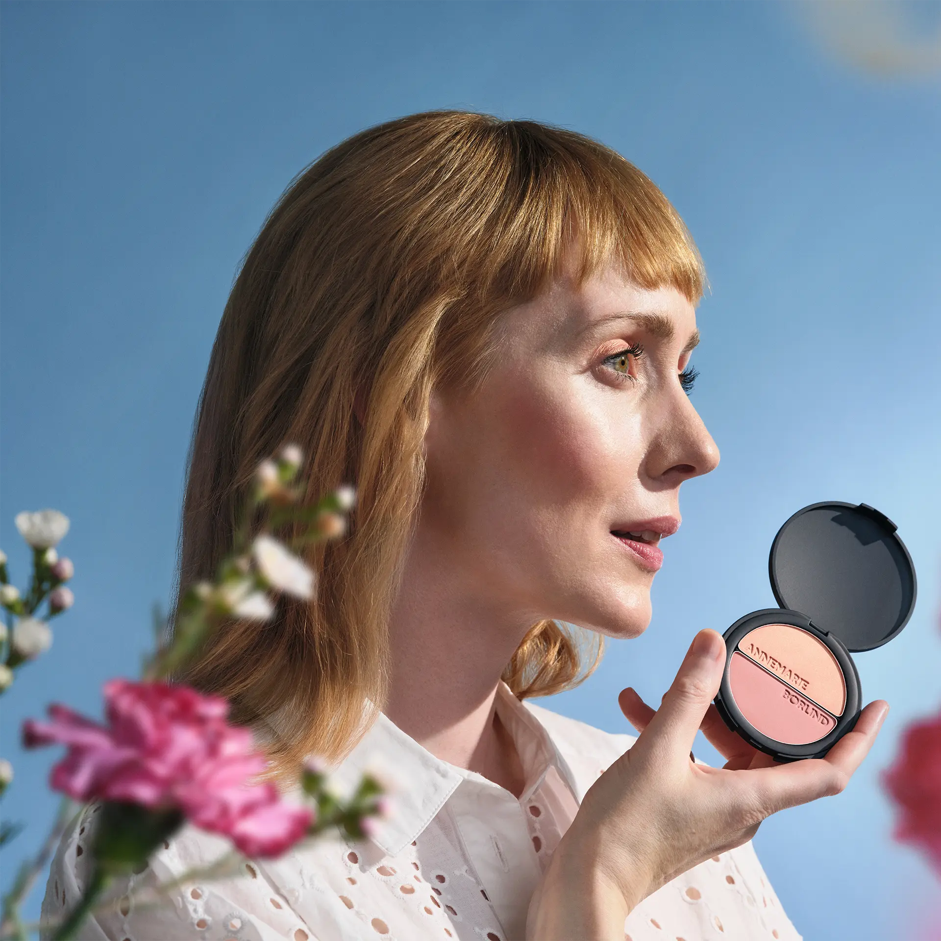 ANNEMARIE BÖRLIND Duo Blush & Eye Shadow in schwarzer Dose mit Logo vor Model mit hellorangenen Haaren