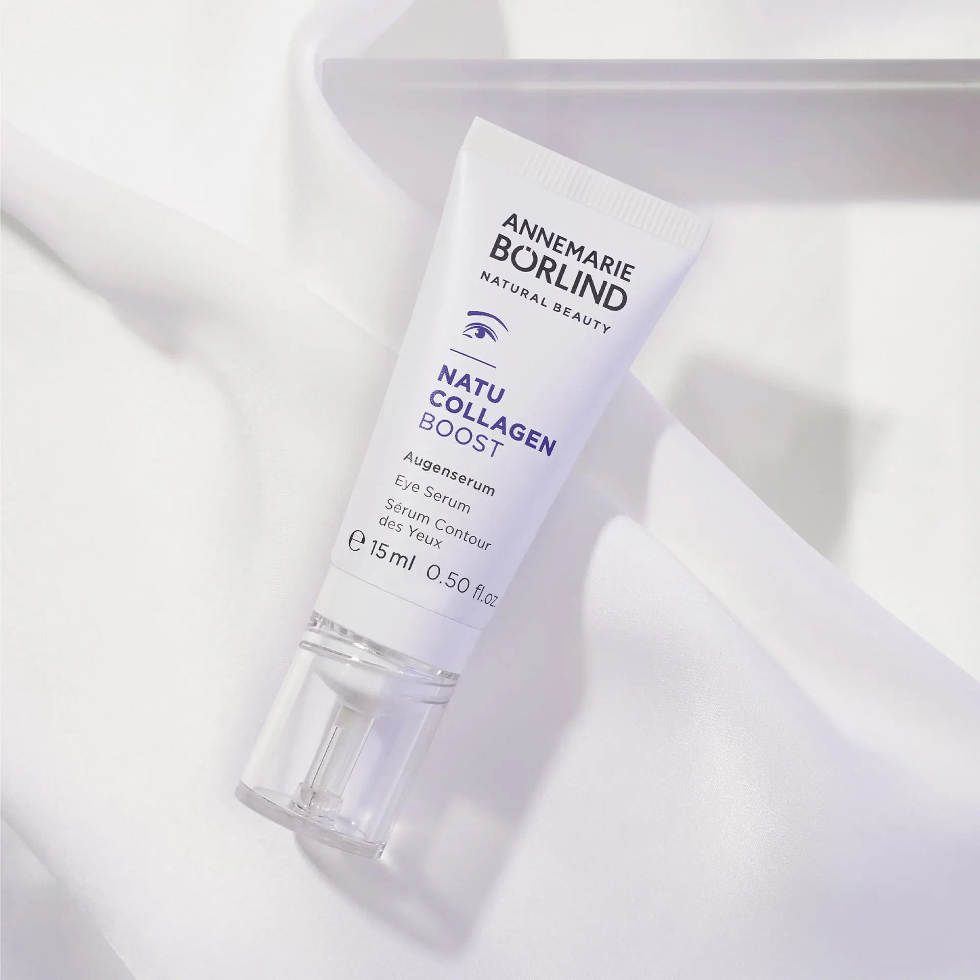 NATUCOLLAGEN BOOST Augenserum als Packshot auf hellem, weichem Stoff drapiert
