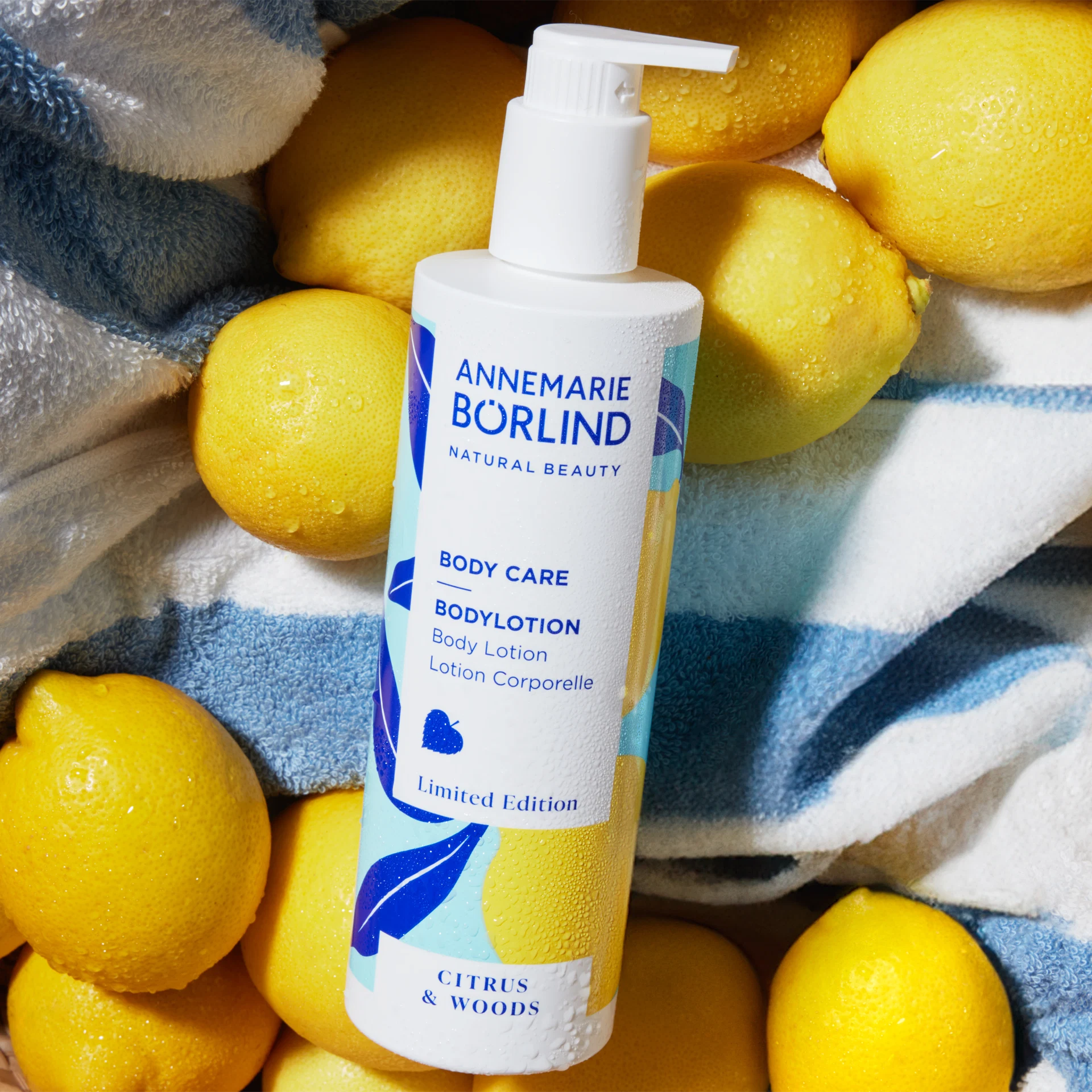 ANNEMARIE BÖRLIND Body Care Bodylotion Citrus & Woods, Limited Edition, umgeben von Zitronen auf Handtuch