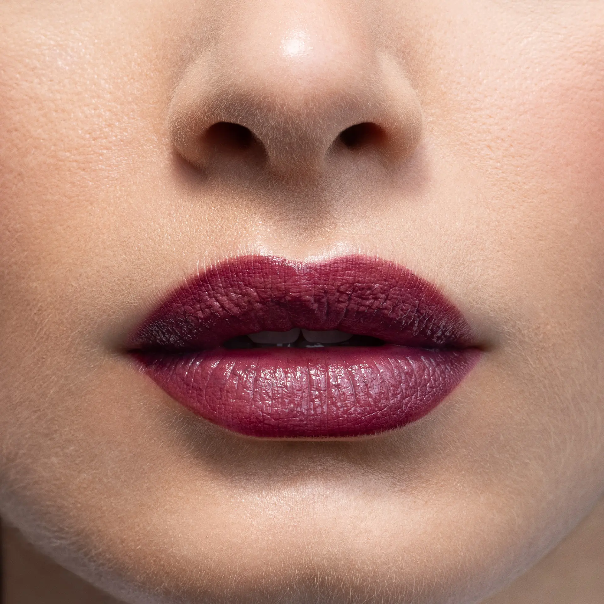 Nahaufnahme von Lippen mit dunkelrotem Lippenstift in matter Textur und leicht geöffnetem Mund