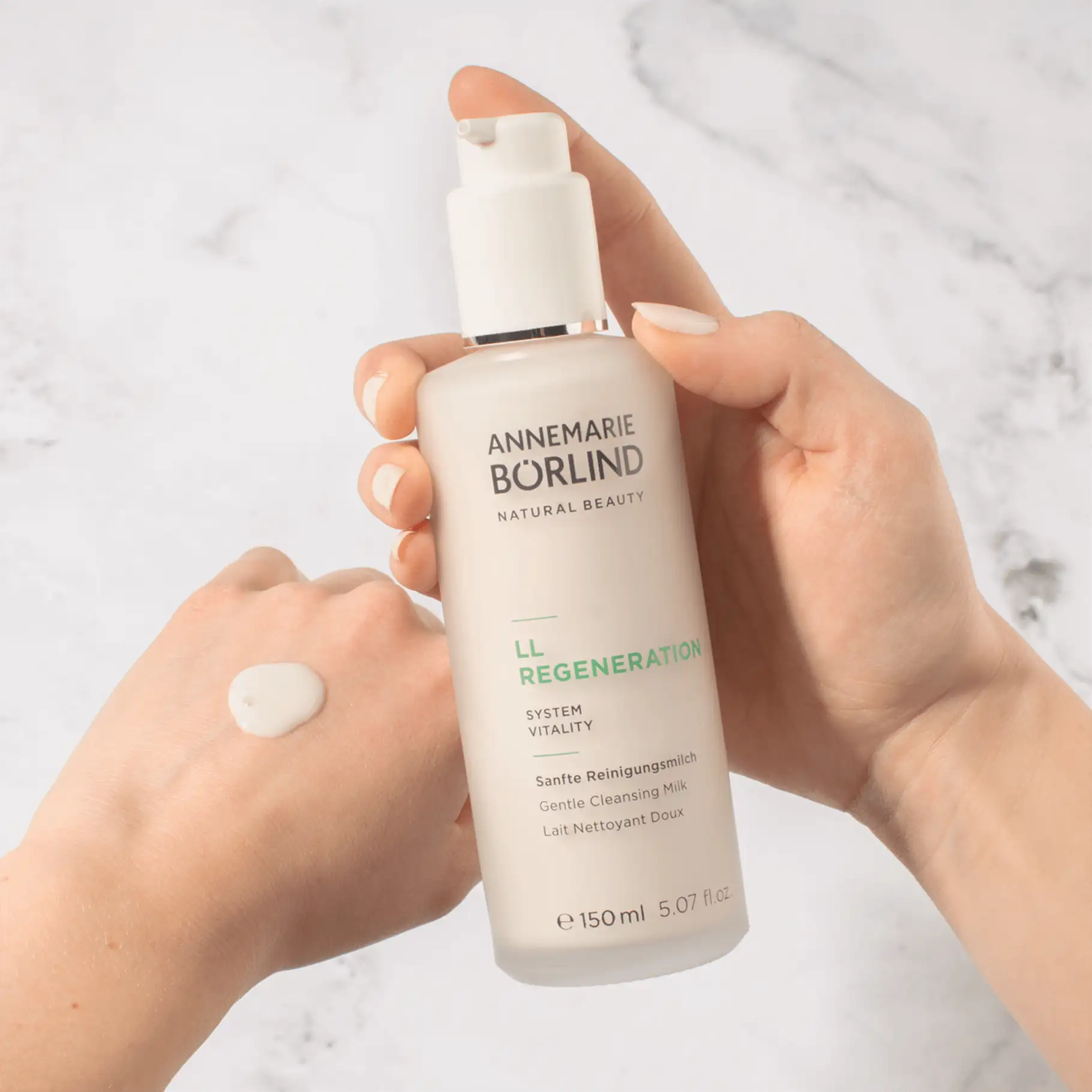 ANNEMARIE BÖRLIND LL REGENERATION sanfte Reinigungsmilch in Hand mit Produktprobe auf Haut
