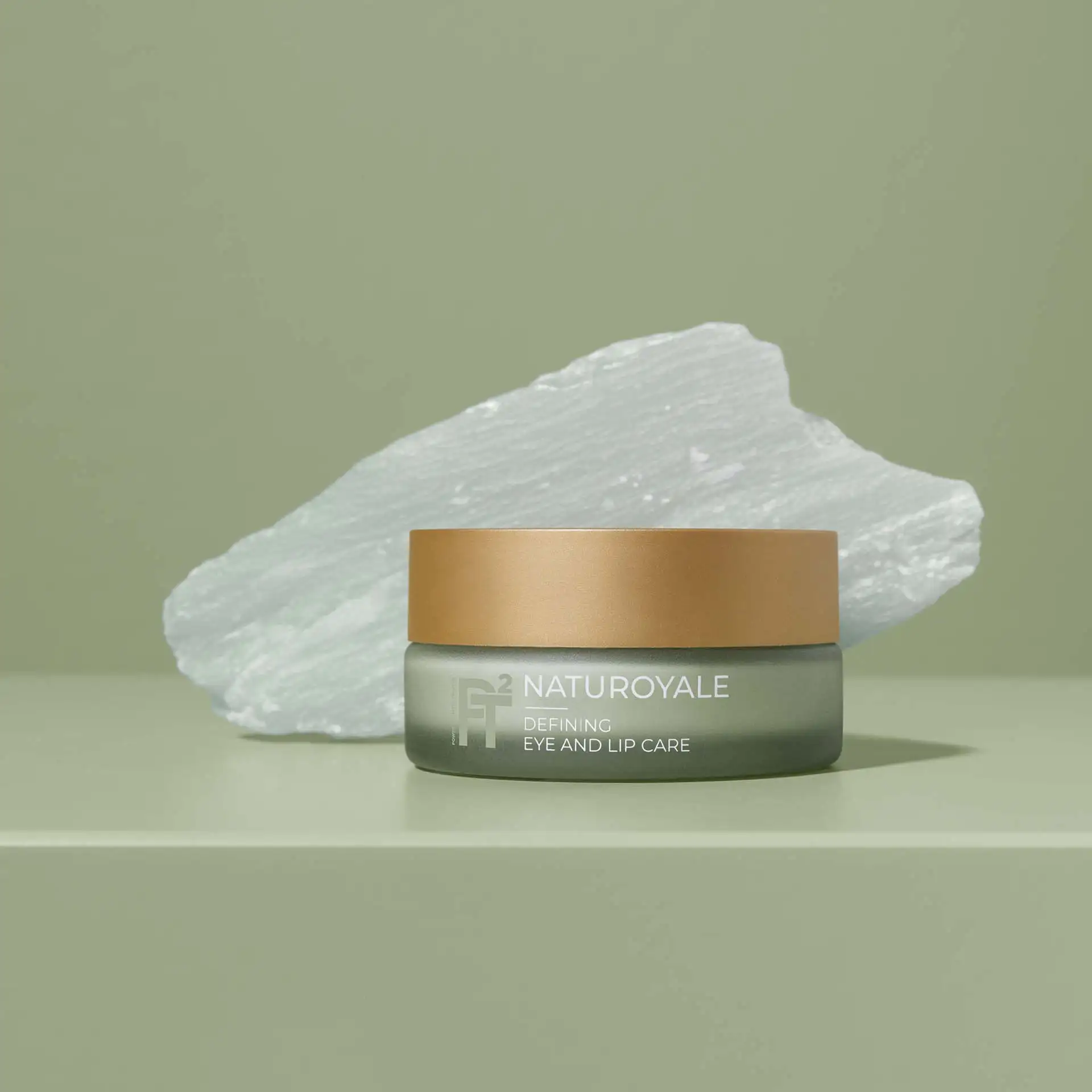 NATUROYALE Defining Eye and Lip Care Tiegel vor weißem Stein auf grünem Untergrund