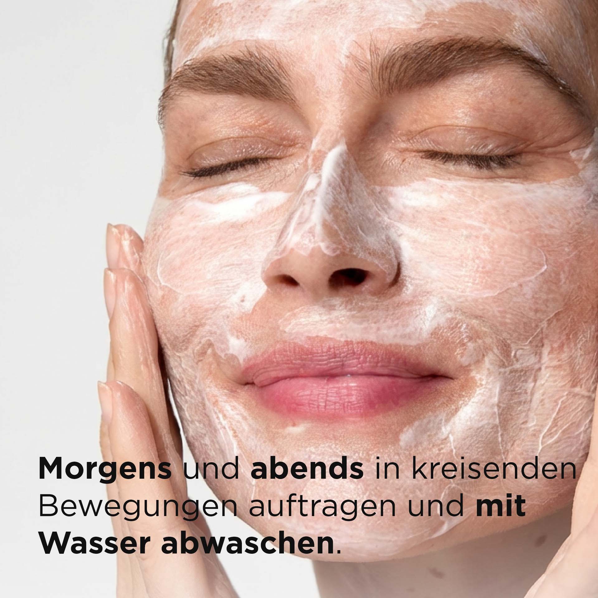 Frau wendet SYSTEM ABSOLUTE Sanfte Reinigungsemulsion im Gesicht an mit Beschreibung