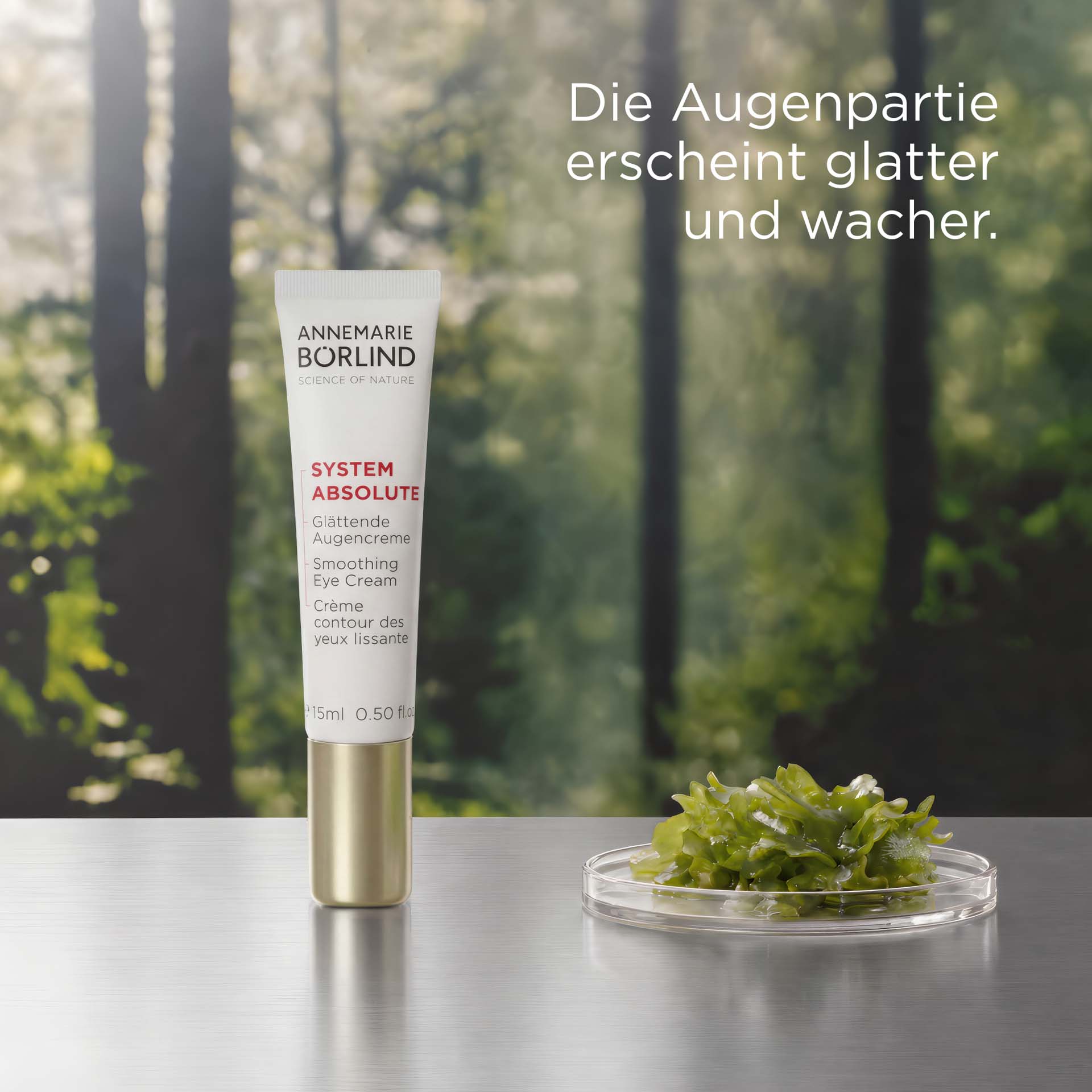 SYSTEM ABSOLUTE Glättende Augencreme Tube mit roter Schrift vor Waldhintergrund mit USP DE