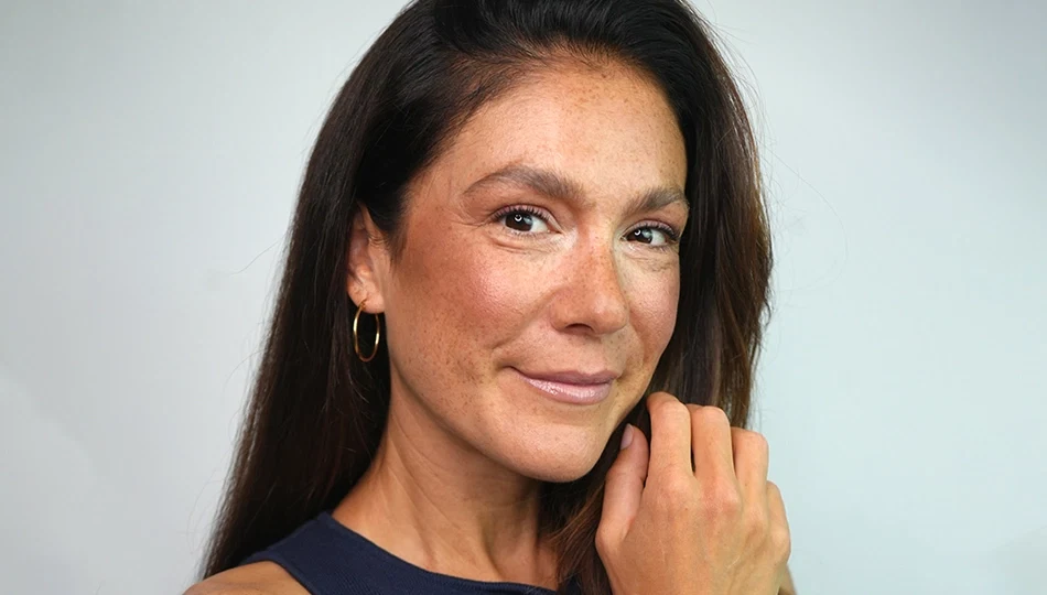 Frau mit warmem Herbst Make-up in natürlichen Braun- und Rosétönen lächelt in die Kamera
