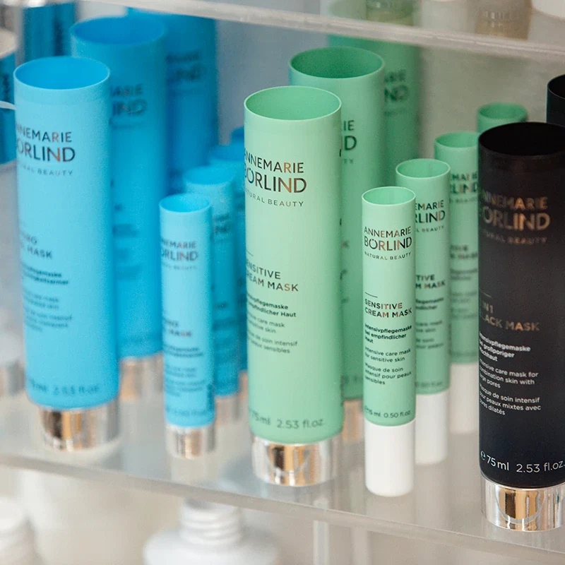 ANNEMARIE BÖRLIND Pflegemasken in blauen, grünen und schwarzen Tuben auf einem Produktregal im Unternehmen