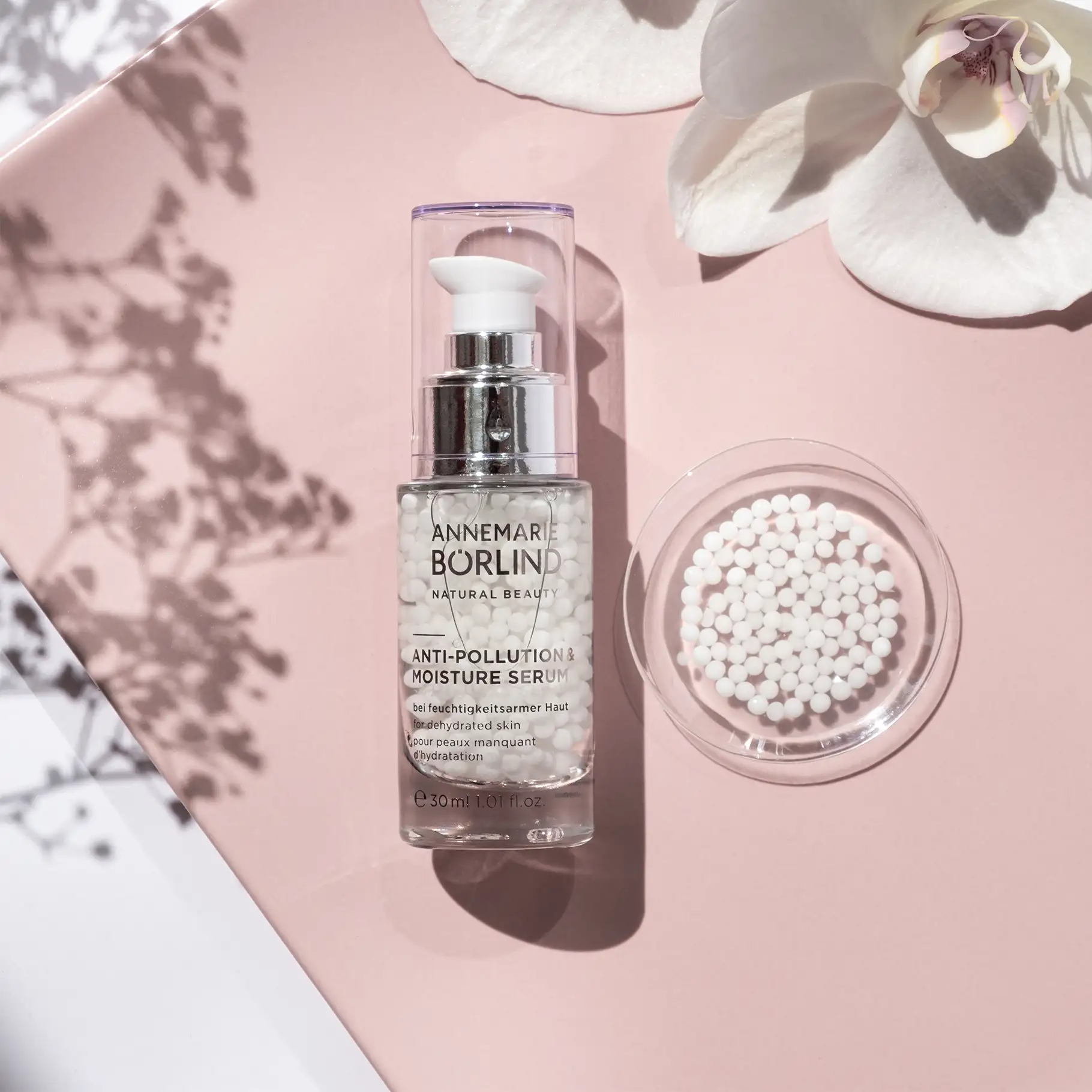 ANNEMARIE BÖRLIND Anti-Pollution & Moisture Serum mit weißen Perlen, Orchidee auf rosa Hintergrund